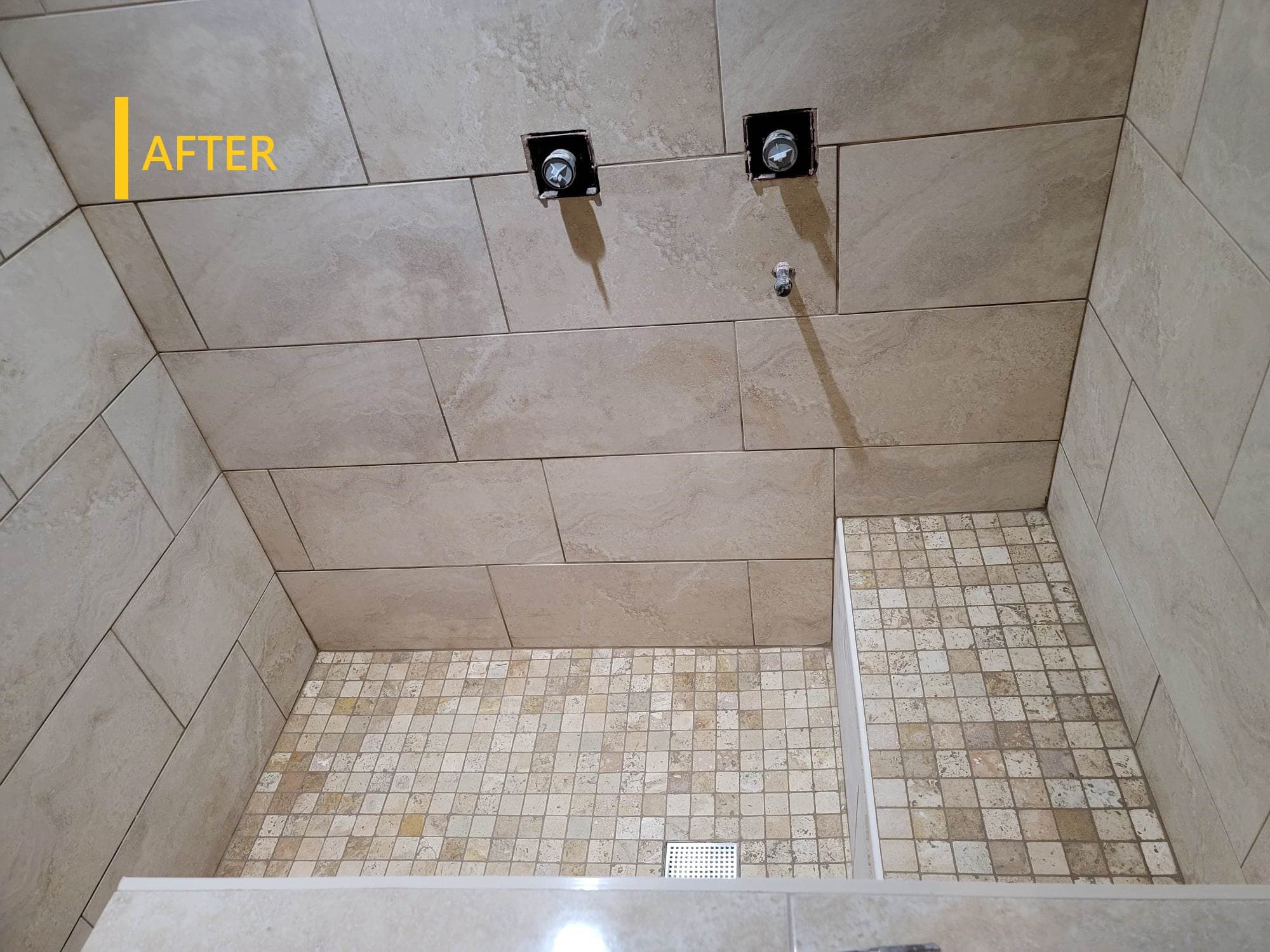 Finished shower with large marble-look tile and glass door
